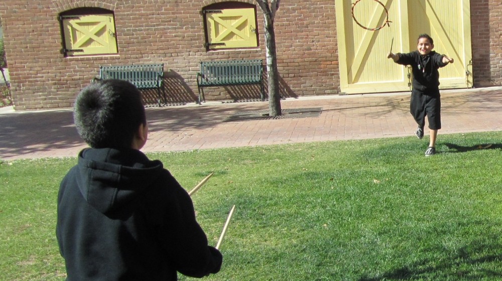Two children playing 19th century games during a Heritage Square field trip.