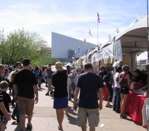 A festival at Heritage Square with the Science Center in the background.