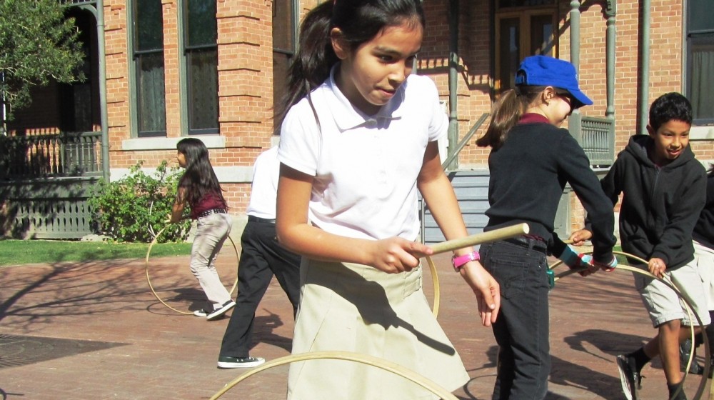 Children playing 19th century games outside Rosson House during at Heritage Square field trip.