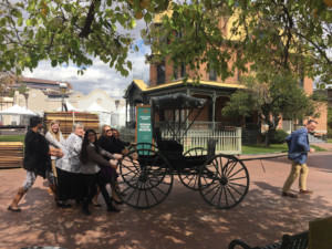 Heritage Square staff and volunteers, having fun with the carriage in front of Rosson House.