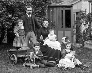 A Victorian Era family, posing for a picture together with several toys.