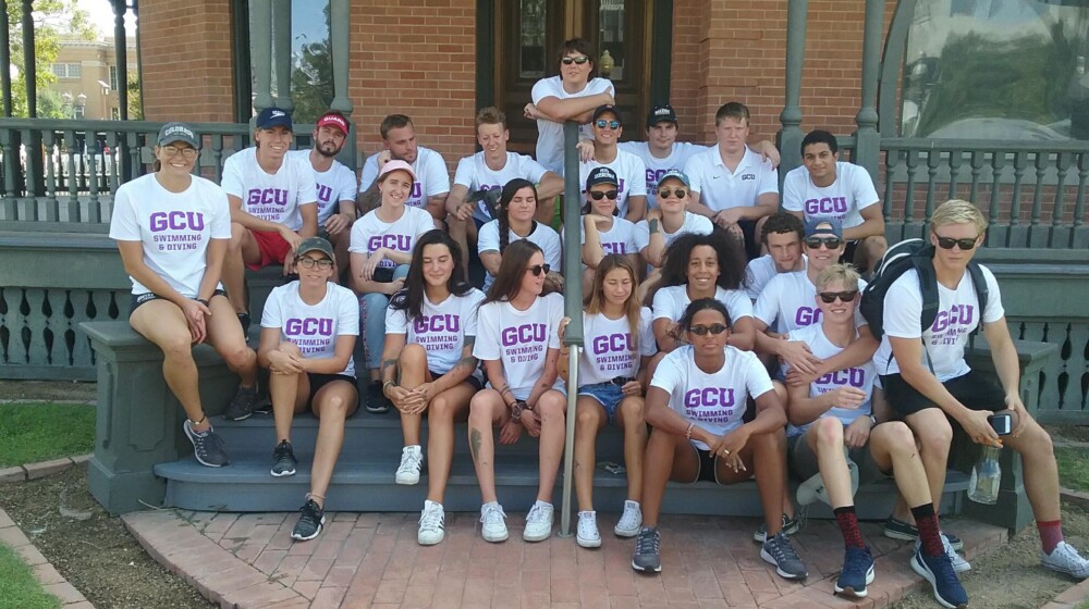A large group of volunteers from Grand Canyon University posing on the steps of Rosson House after their day of volunteering.