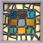 Small square window St. Paul's Monastery in Jarrow, England, with individual, non-uniform colored pieces of glass set to form smaller squares within the frame.