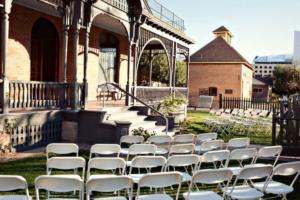 Chairs set up for a wedding in the front yard of Rosson House, looking toward the front porch.