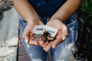 Hands holding coins and a note that says, "Make a Change."