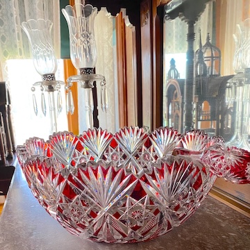 A picture of an antique, red and clear cut glass punchbowl.