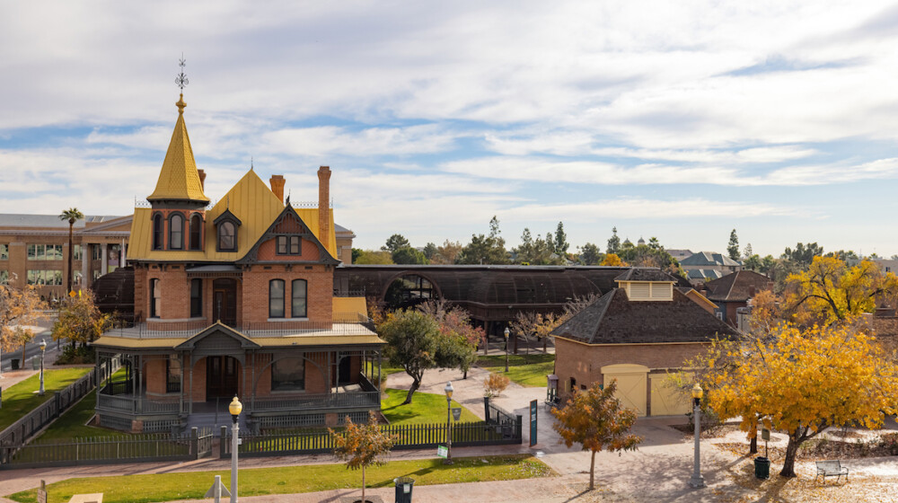 A picture of Rosson House Museum and the Visitor Center Carriage House during winter at Heritage Square, with the leaves on many of the trees turing yellow.