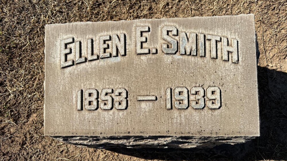 A picture of a horizontal, rectangle-shaped grave marker belonging to Ellen E. Smith, 1859-1939.