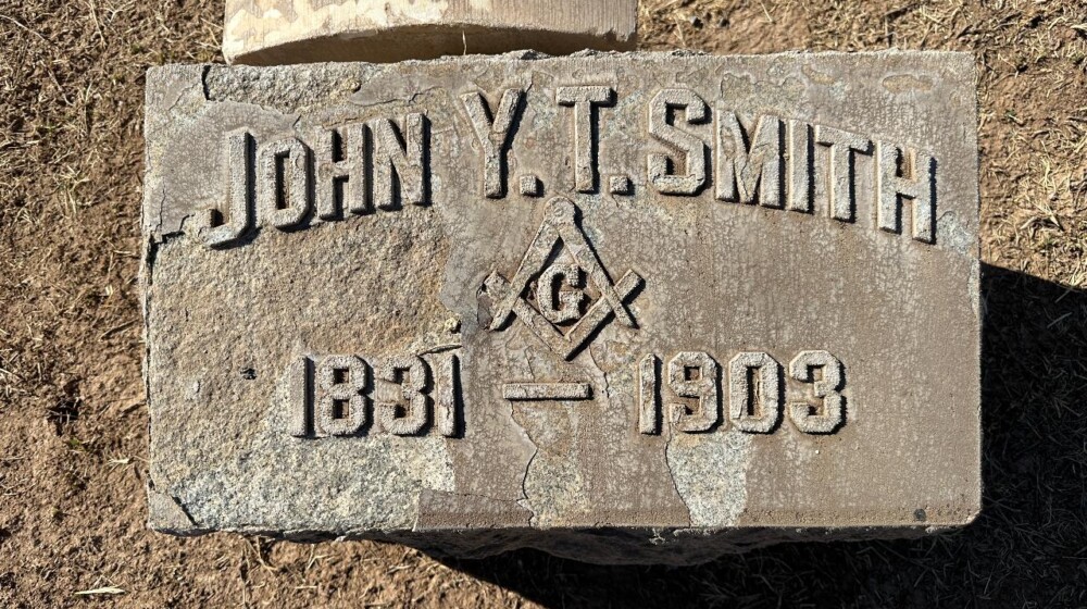A picture of a horizontal, rectangle-shaped grave marker belonging to John Y. T. Smith, 1831-1903.