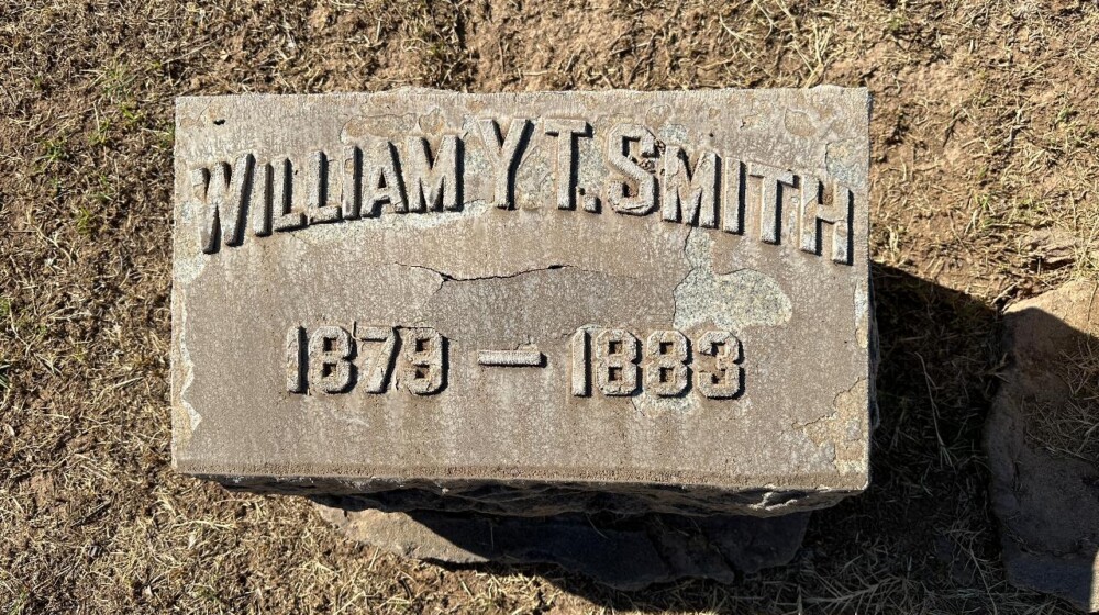 A picture of a horizontal, rectangle-shaped grave marker belonging to William Y. T. Smith, 1879-1883.